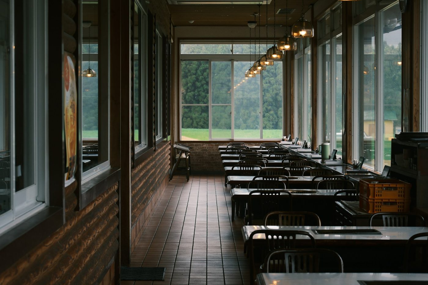 A long restaurant dining room lit by its windows