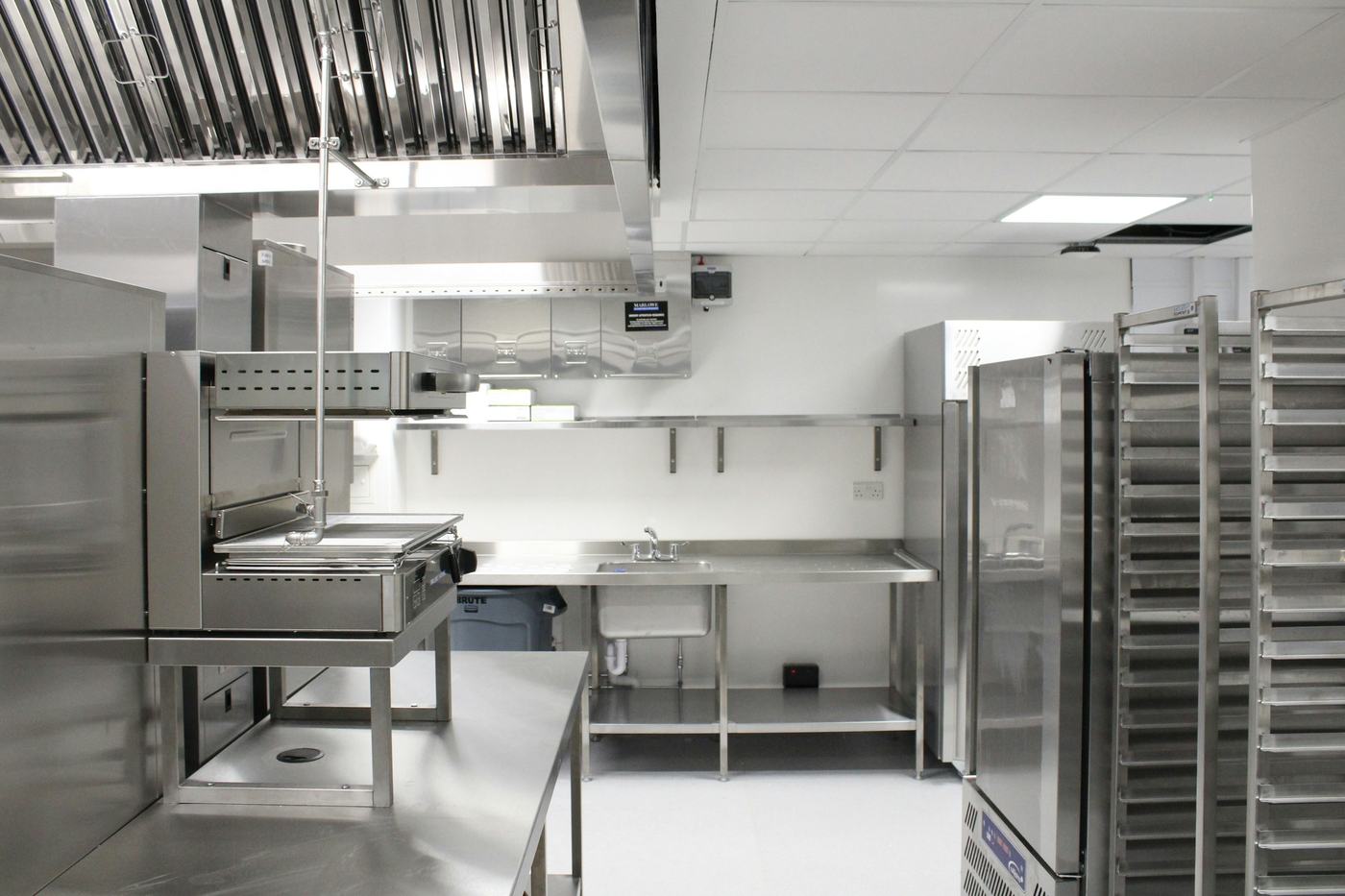 A back-of-house kitchen with stainless refrigeration and racking