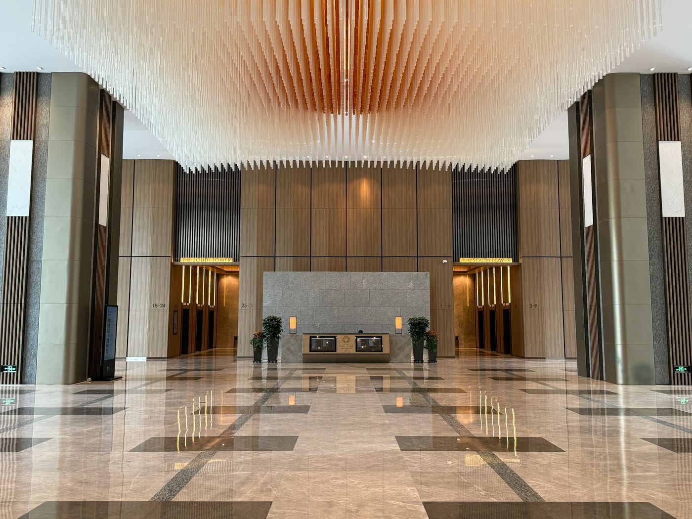 A large lobby with a polished stone floor reflecting the lights