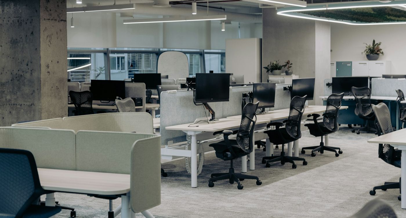 An open-plan office with rows of desks and task chairs
