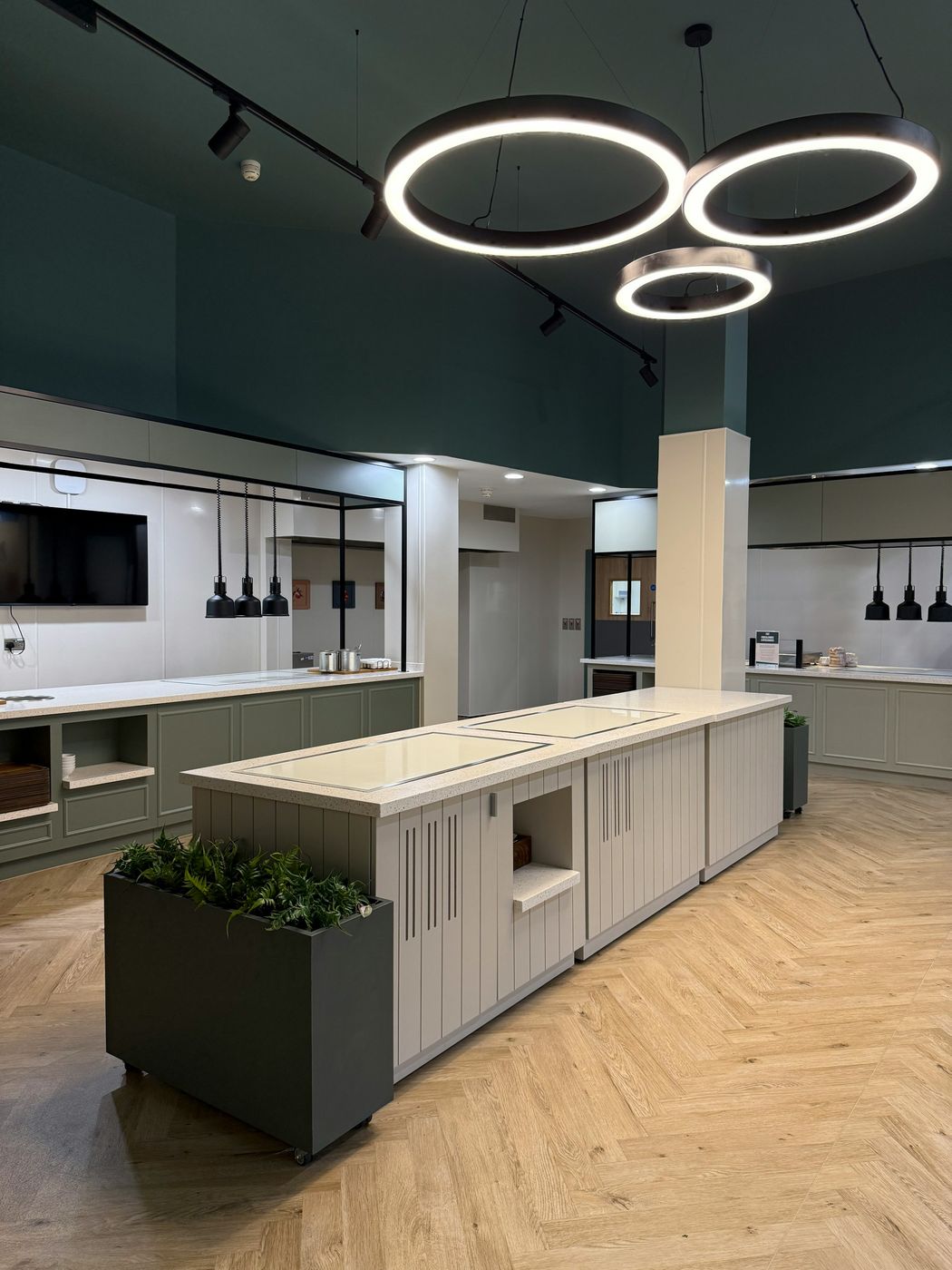 A new servery with a long island counter, ring pendant lights and a herringbone floor